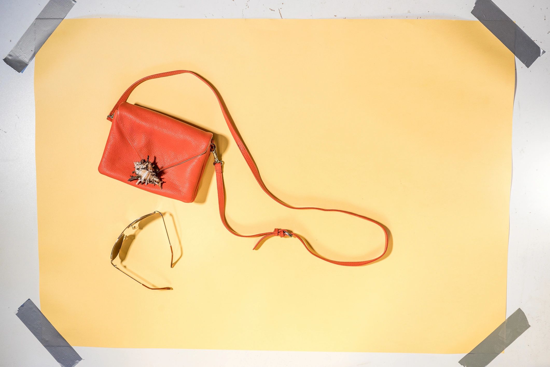 Editorial flatlay of handbag and sunglasses