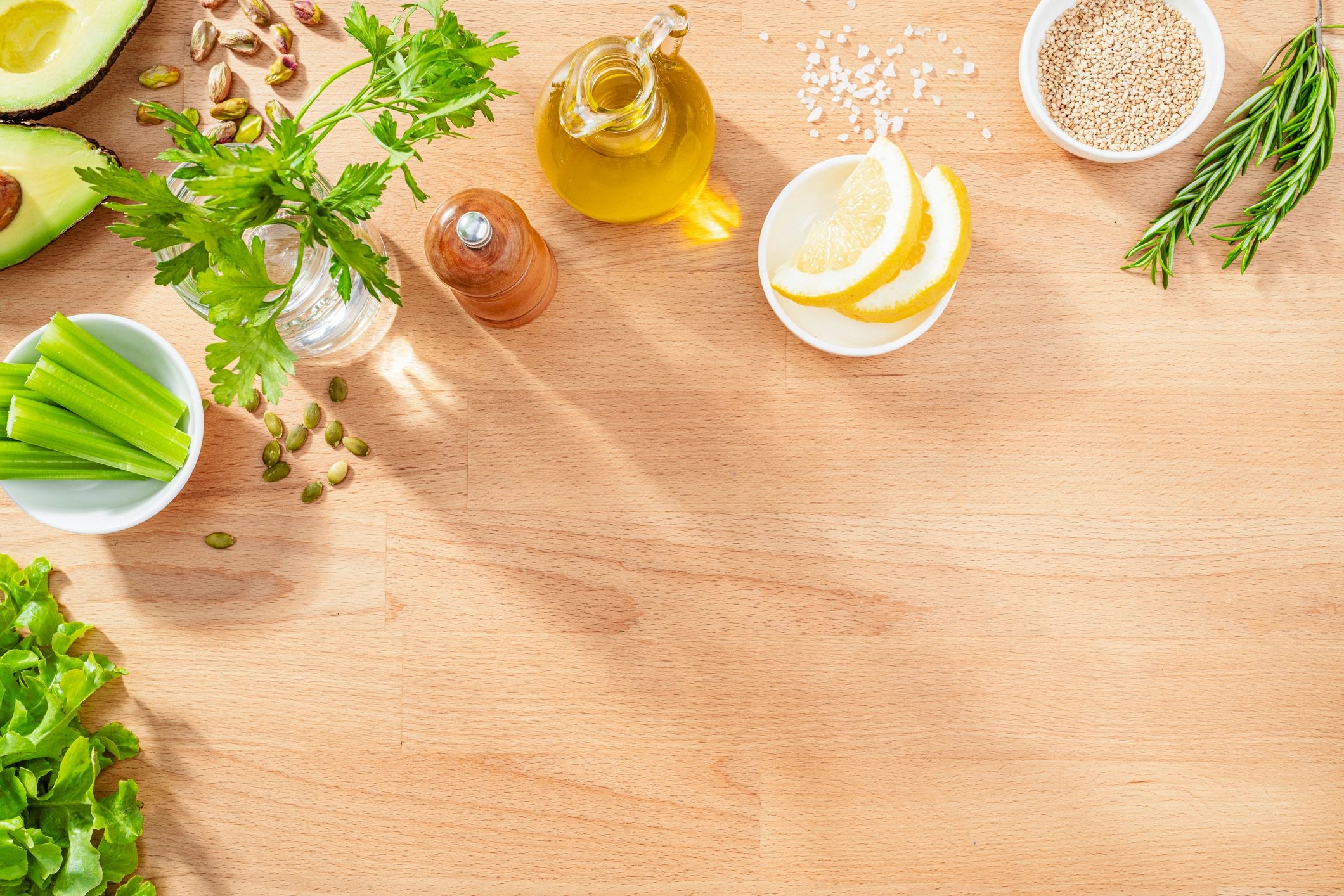 Fresh green ingredients arranged on a wooden surface for a recipe flatlay