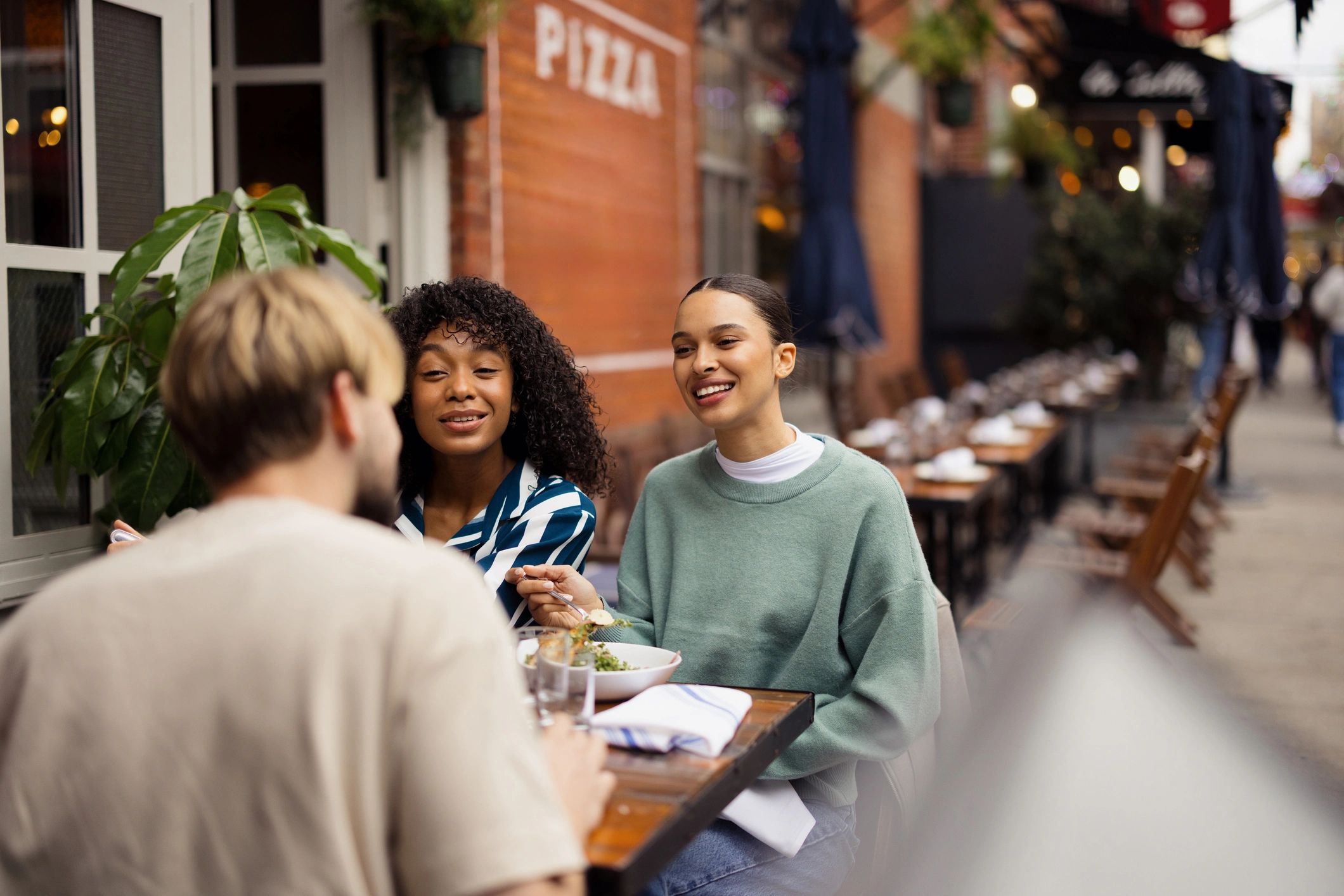 Friends dining at an outdoor New York City cafe